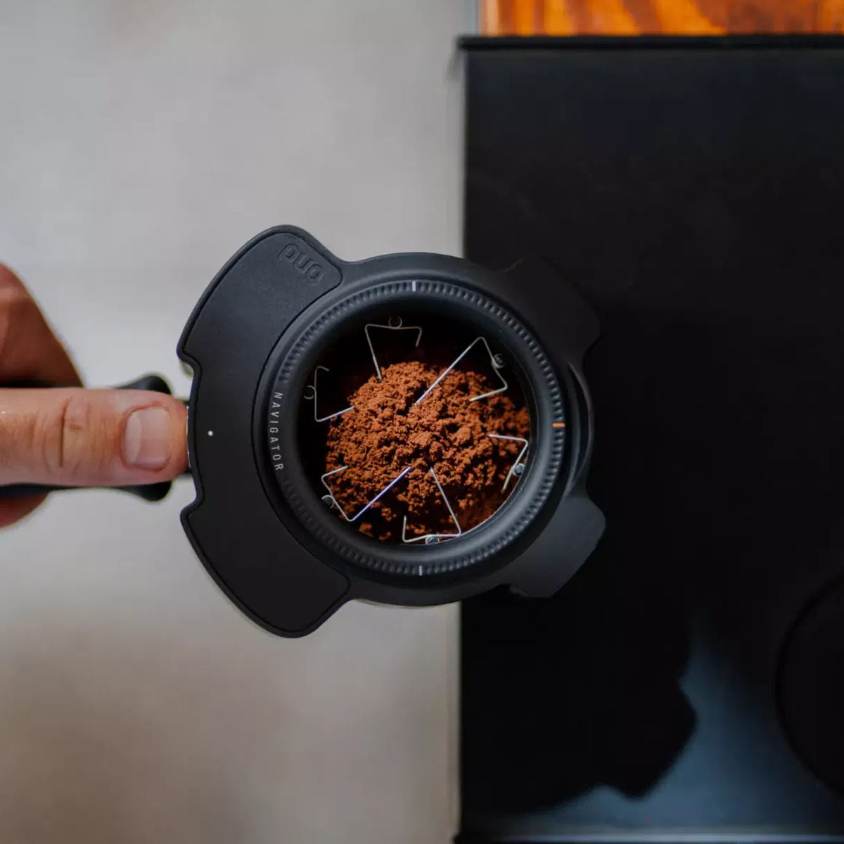 Puq Navigator WDT tool being used on top of portafilter with coffee grounds