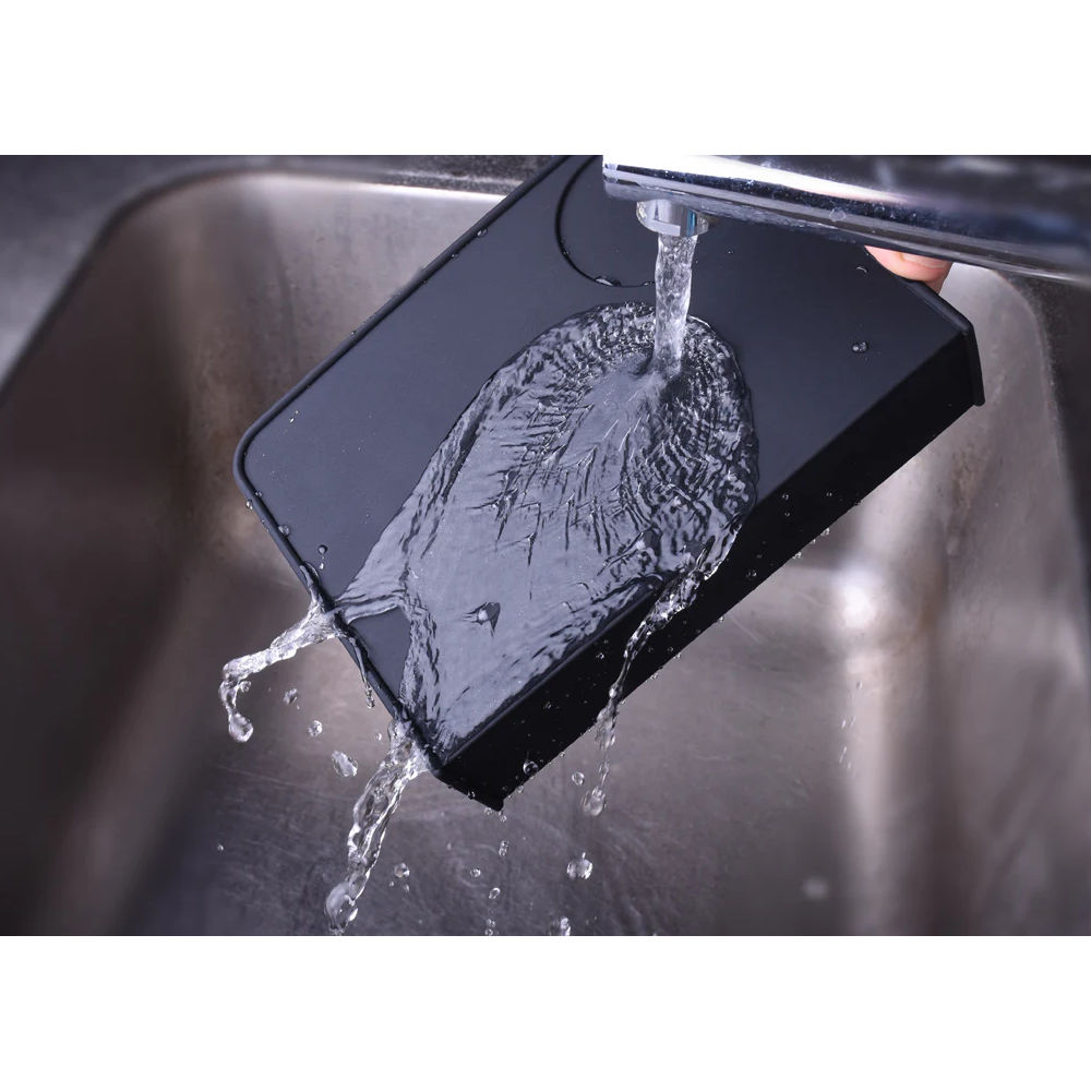 Washing Joe Frex Angled Corner Black silicone Tamping Mat under a tap
